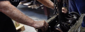 A technician readies himself to remove a crankshaft from a Detroit Diesel Engine